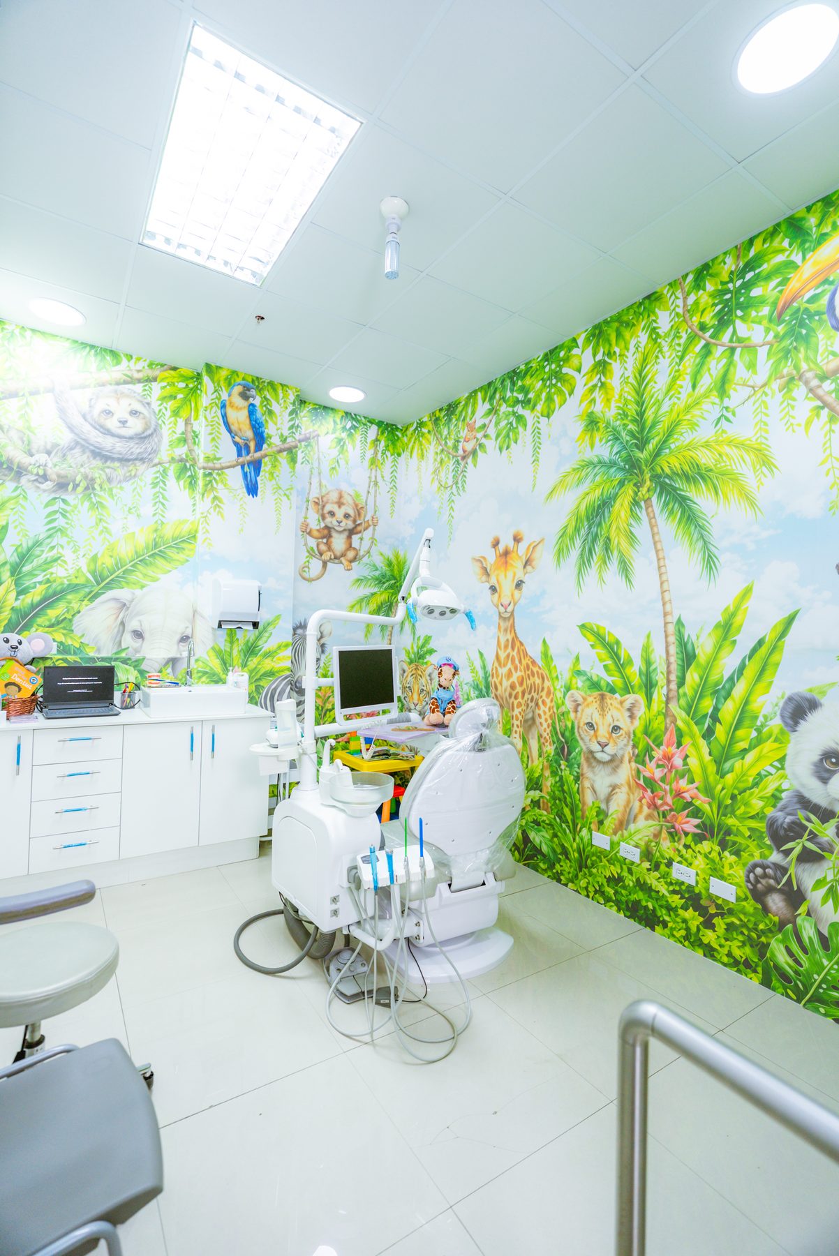 Vista del consultorio infantil con el mural de selva y el equipo dental